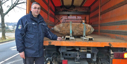Ein Mitarbeiter des Kampfmittelräumdienstes mit der entschärften 5-Zentner-Bombe in Troisdorf-Spich